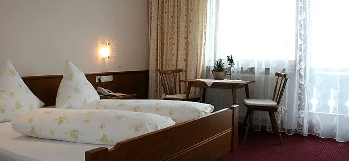 Schlafzimmer mit Doppelbett und Tisch am Fenster