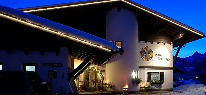 Haus Schnetzer am Abend, verschneit und beleuchtet